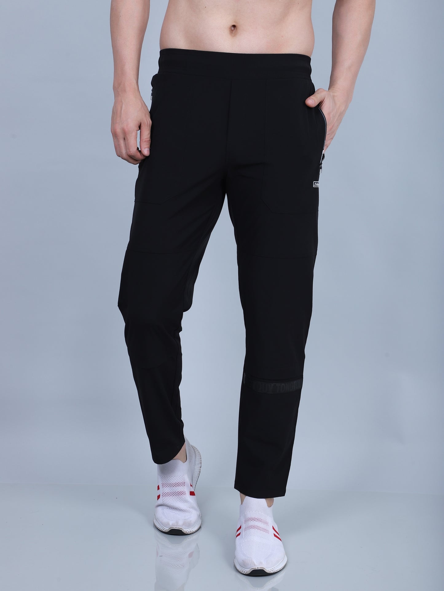 Person wearing black pants on a gray background