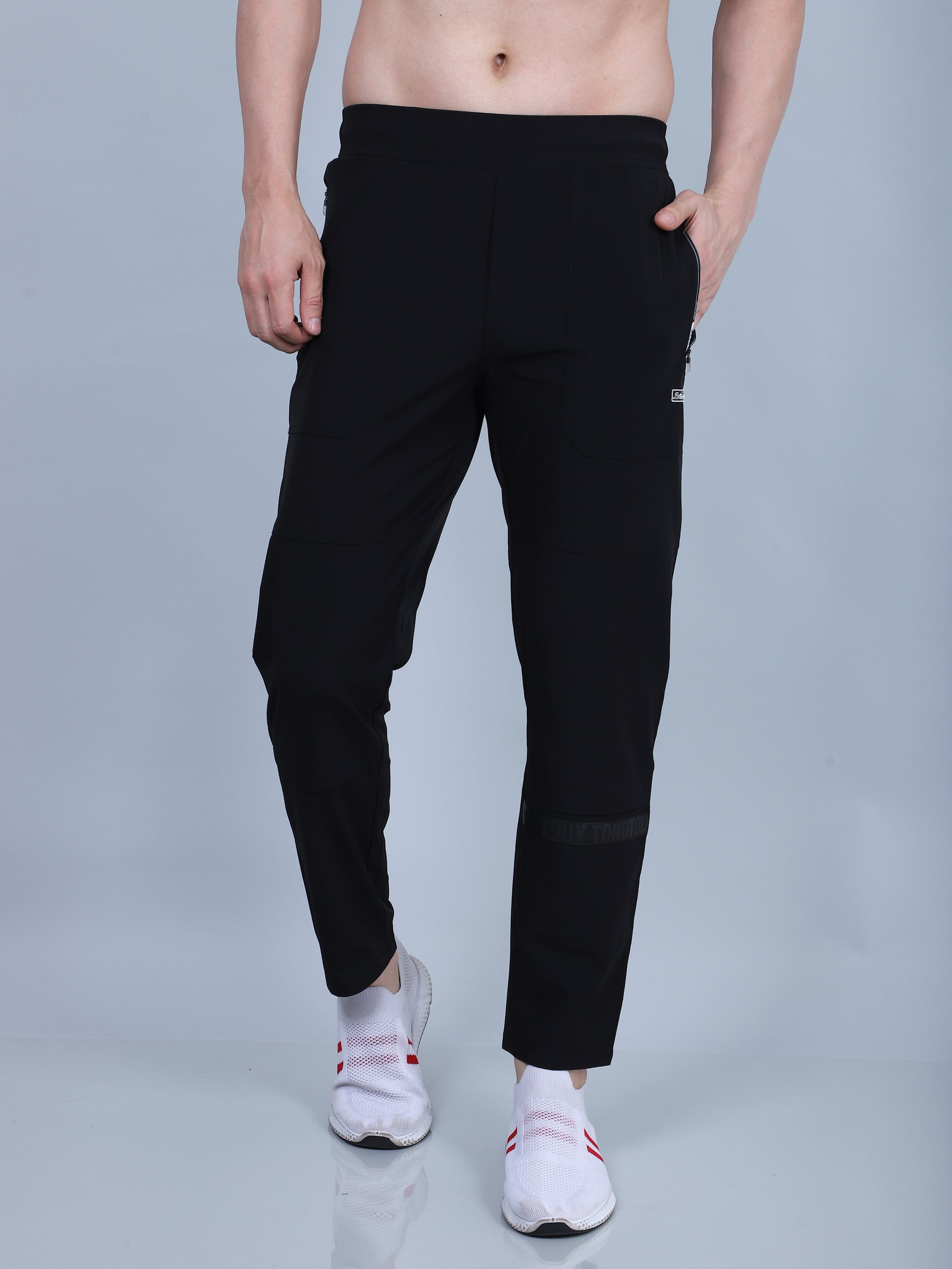 Person wearing black pants on a gray background