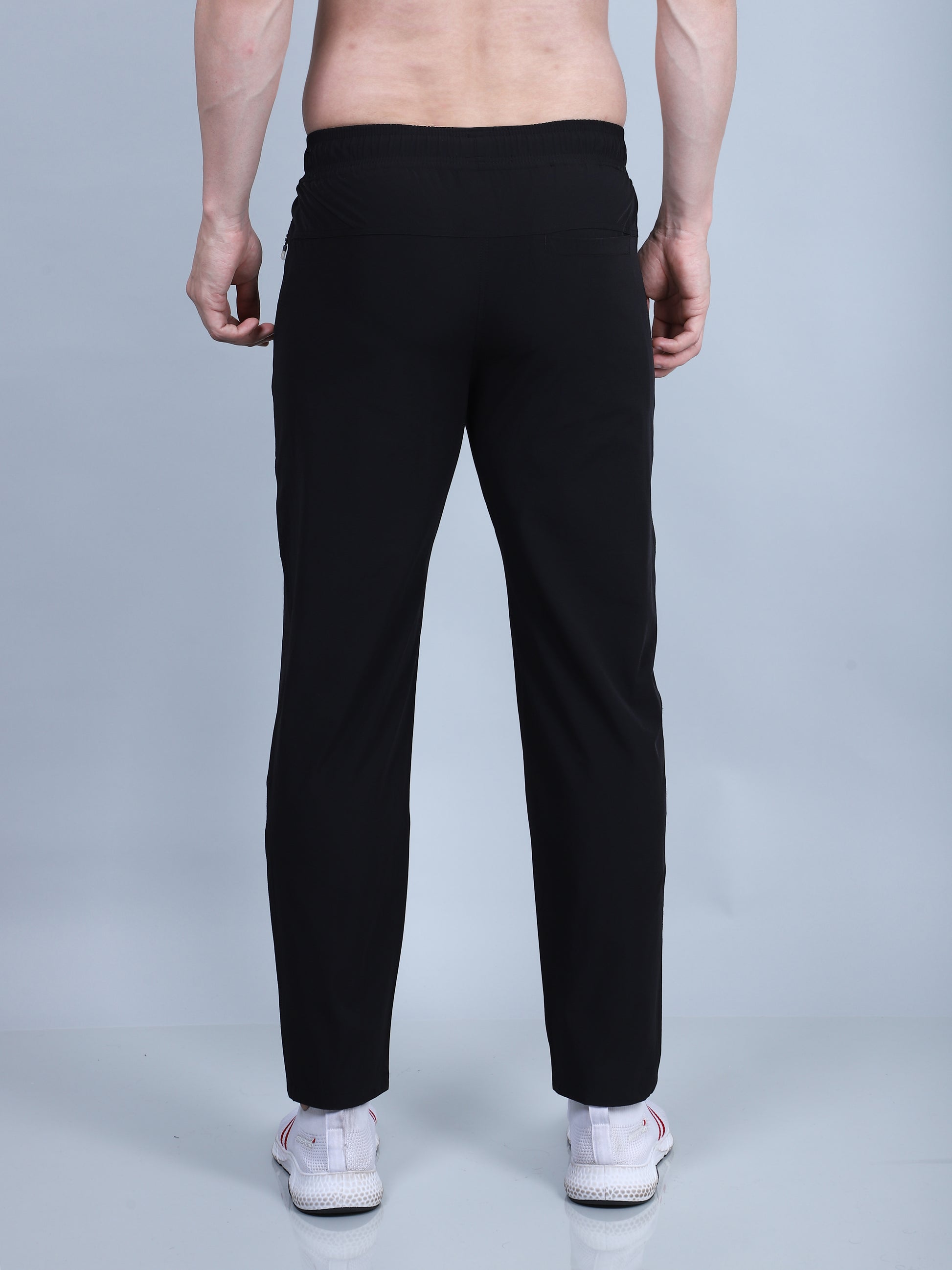 Person wearing black pants on a light gray background