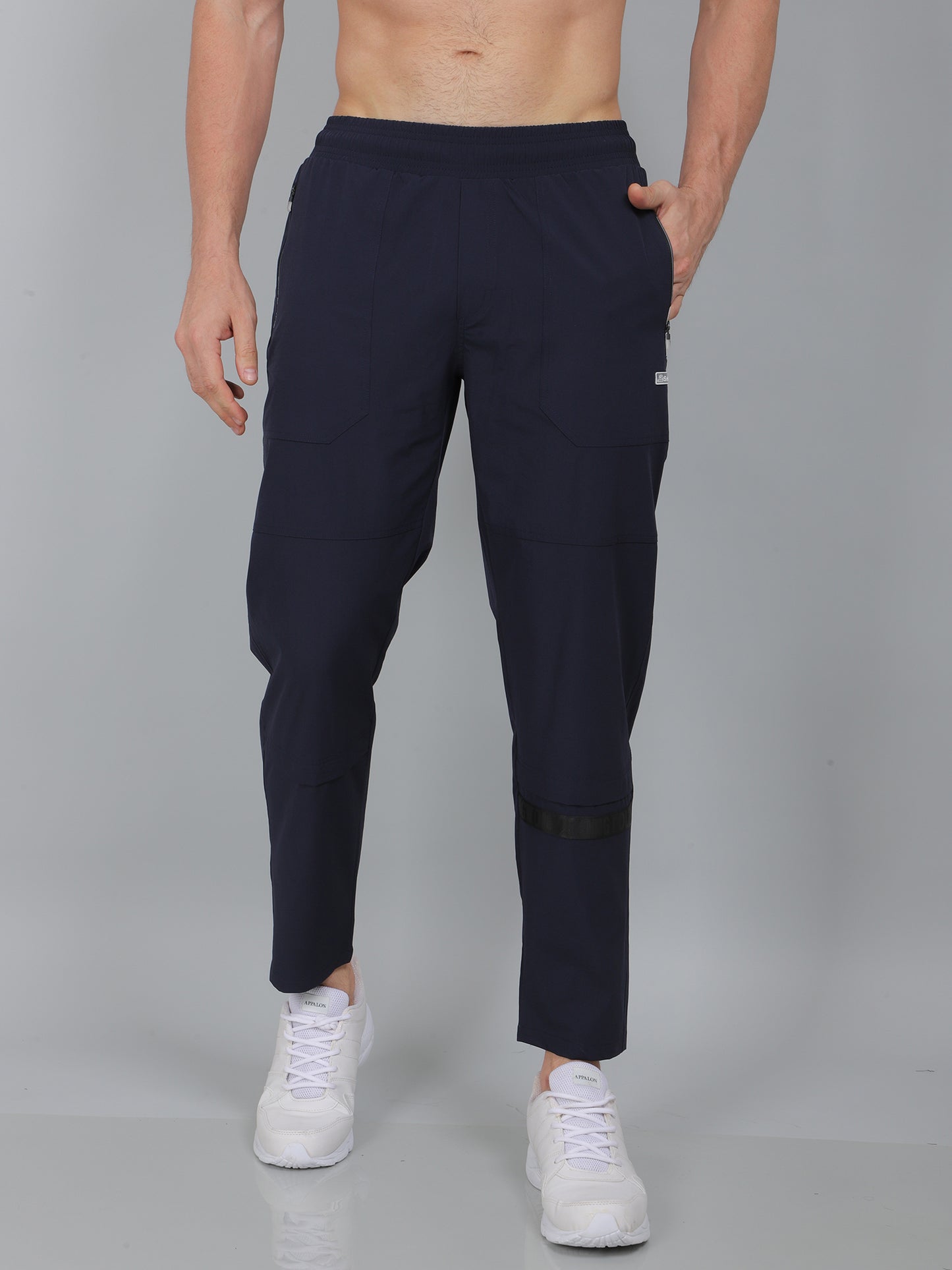 Person wearing navy blue jogger pants on a gray background