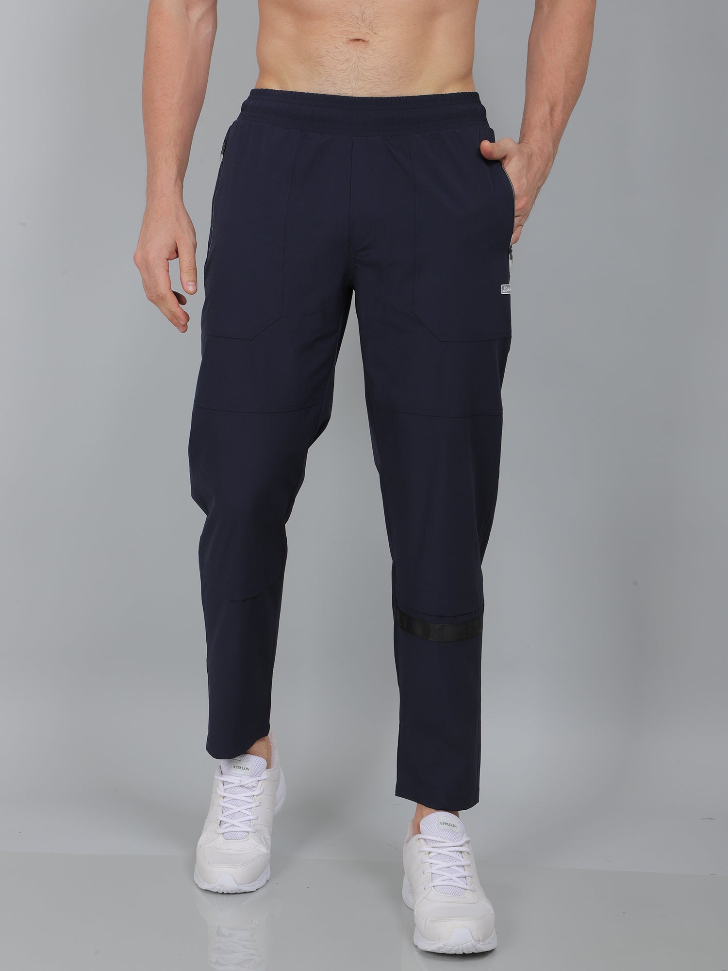 Person wearing navy blue jogger pants on a gray background