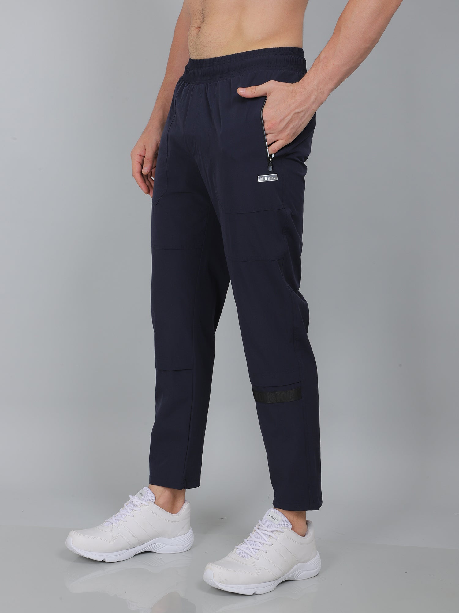 Person wearing navy blue pants with a gray background