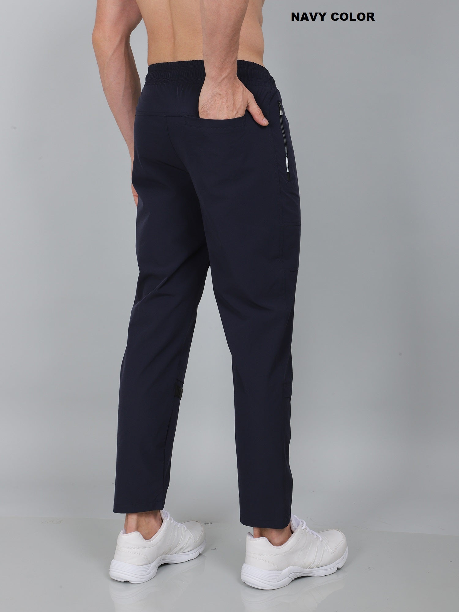 Navy blue pants worn by a person on a gray background