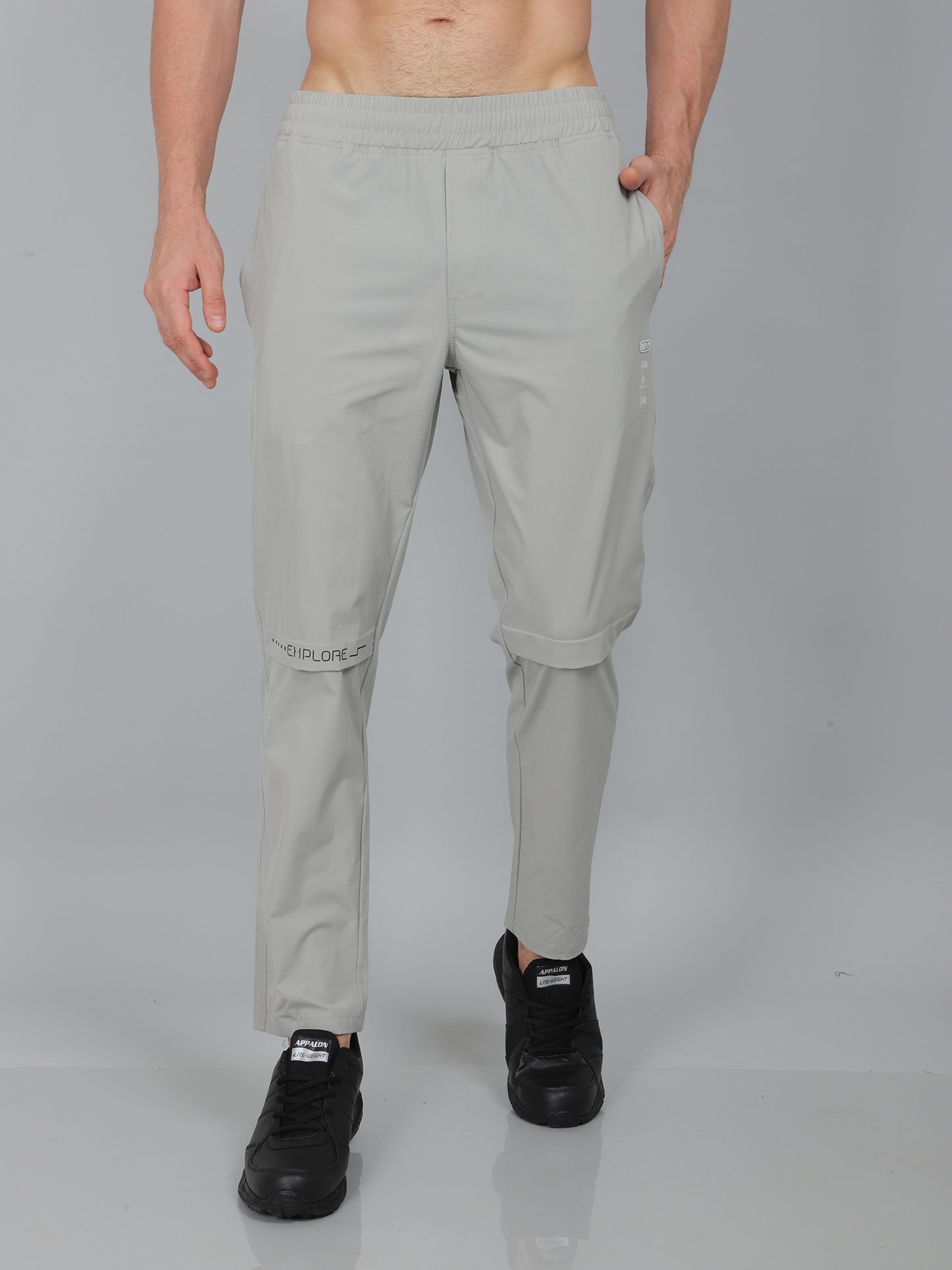 Person wearing light gray pants on a plain background
