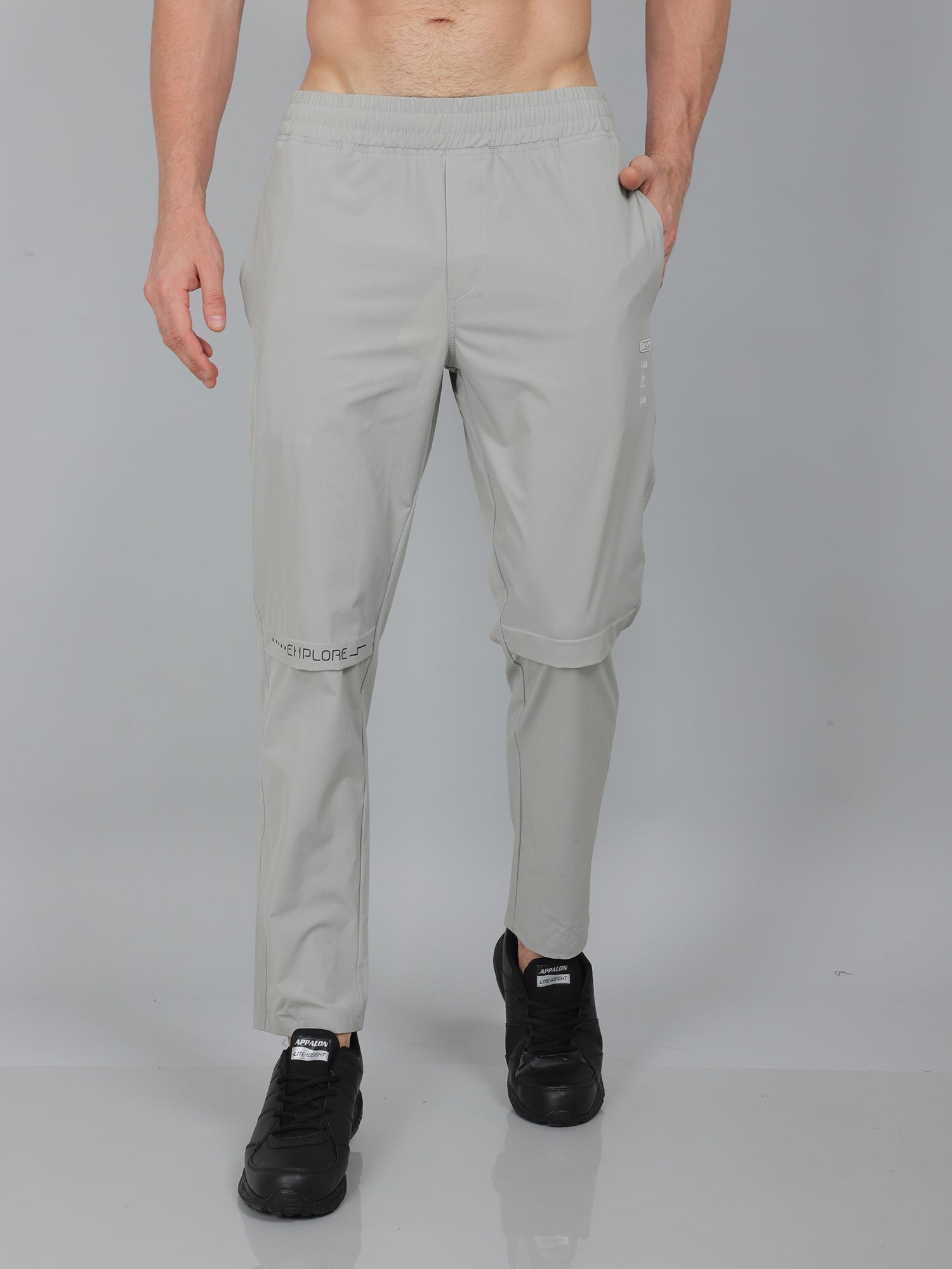 Person wearing light gray pants on a plain background