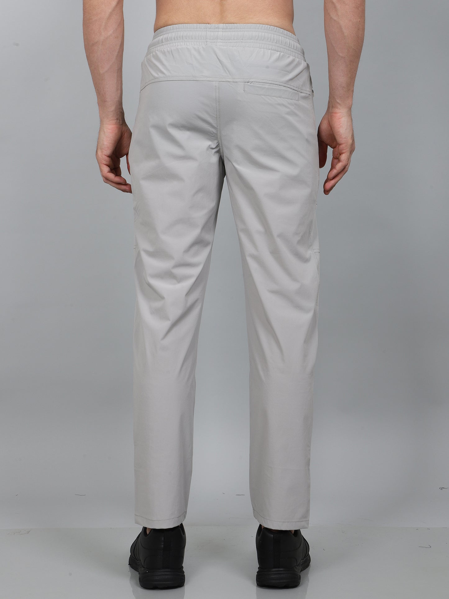 Person wearing light gray pants on a plain background