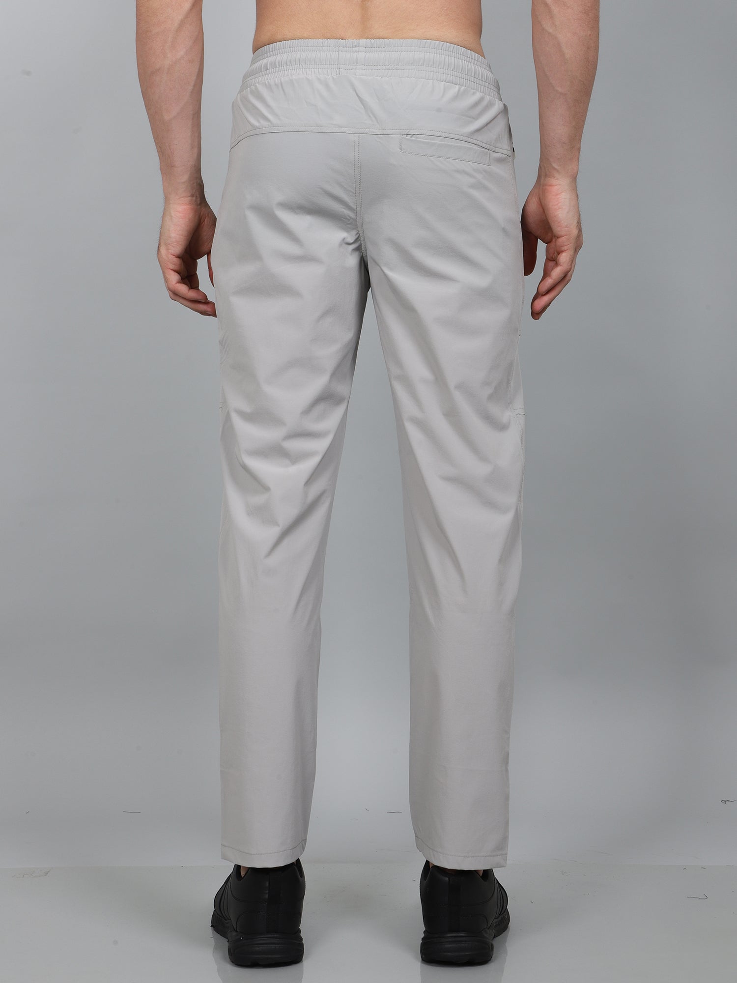 Person wearing light gray pants on a plain background