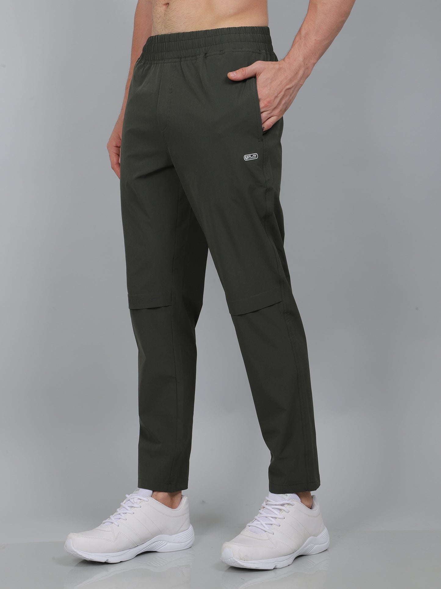 Person wearing dark green cargo pants with a visible brand logo on a gray background