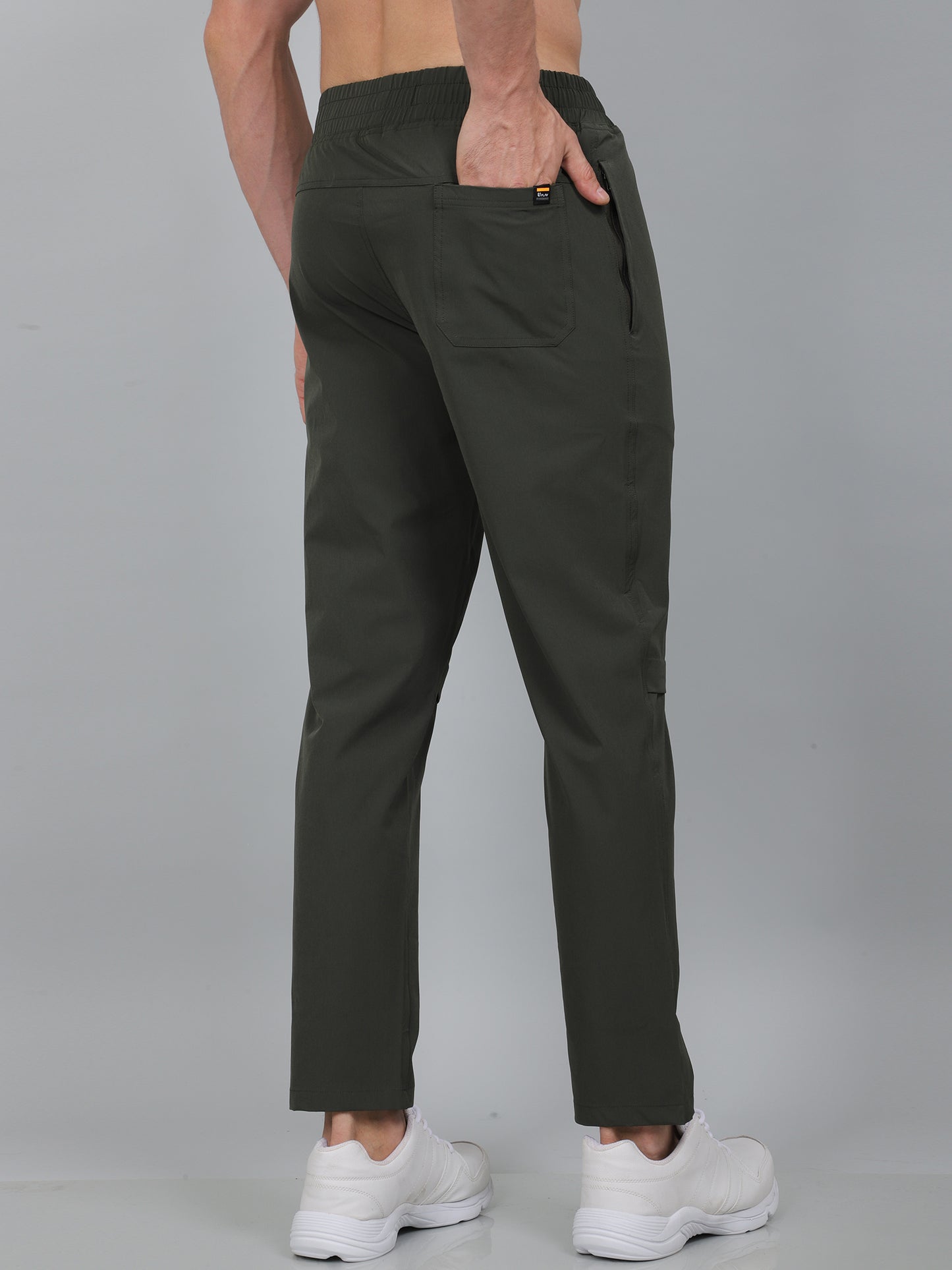 Person wearing dark green pants on a gray background
