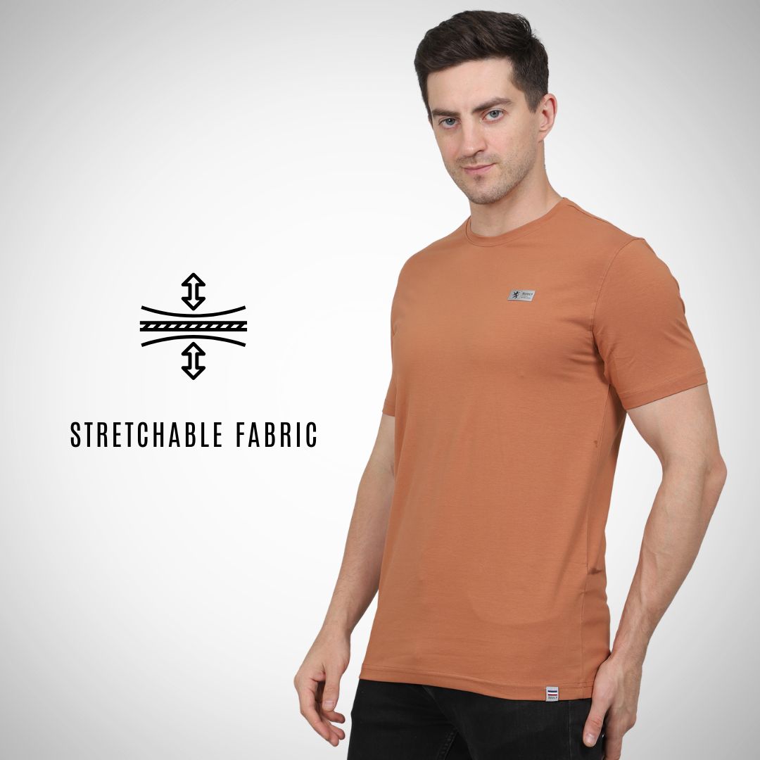 Man wearing a brown t-shirt with stretchable fabric feature on a white background