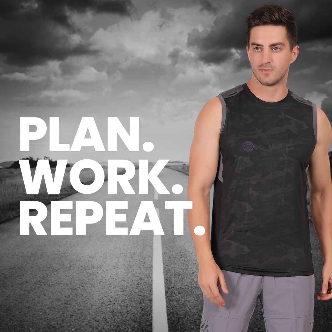 Man in athletic wear with 'PLAN. WORK. REPEAT.' text against a road and mountain backdrop