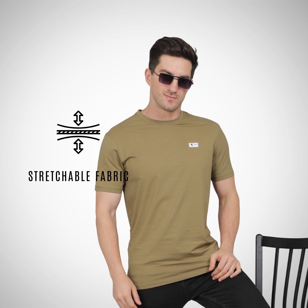 Man wearing a green t-shirt with sunglasses, sitting on a chair against a white background.