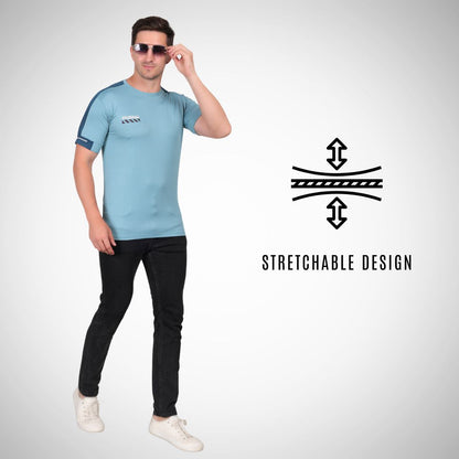 Man wearing a light blue t-shirt and black pants with sunglasses, standing against a white background.