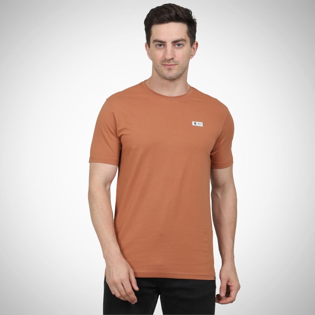 Man wearing a brown t-shirt with a small logo on a white background