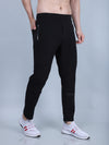 Person wearing black jogger pants with white sneakers on a gray background