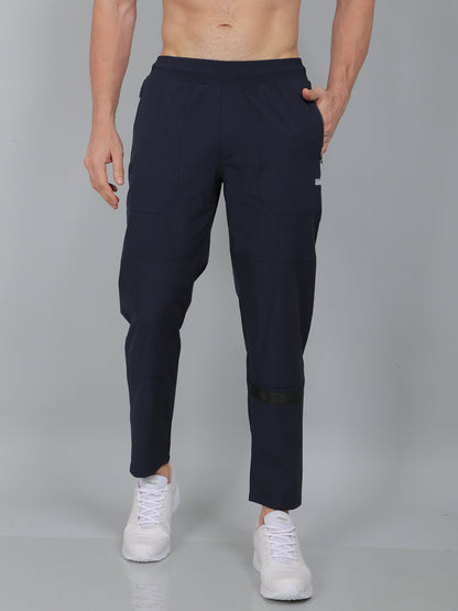 Person wearing navy blue jogger pants on a gray background