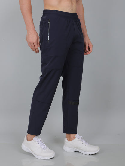 Person wearing navy blue pants with white sneakers on a gray background