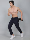 Man in navy jogger pants holding a dumbbell against a gray background
