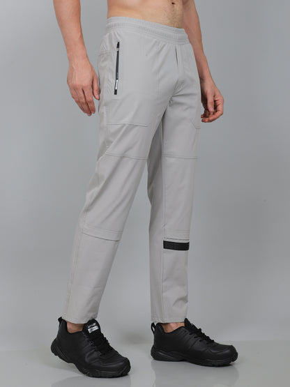 Person wearing light gray pants with black accents on a gray background