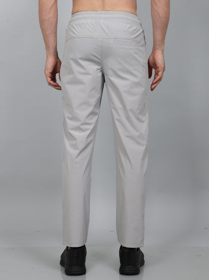 Person wearing light gray pants on a plain background