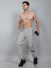 Man wearing light gray athletic pants on a plain background