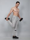 Man in light gray athletic pants posing with plain background