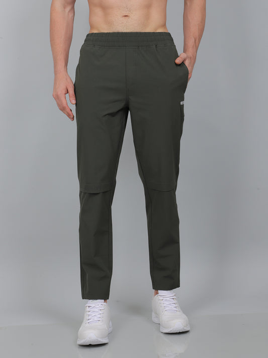 Person wearing dark green cargo pants on a gray background