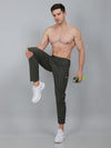 Man posing in dark pants and white sneakers on a gray background